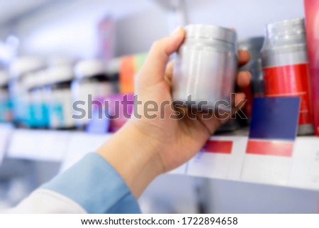 At the chemist, Medicines and healthcare products arranged in shelves, Pharmacist holding supplements Vitamin bottle in pharmacy drugstore for prescribe to patient. Pharmaceutical prescribing concept. Royalty-Free Stock Photo #1722894658