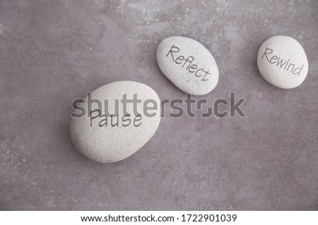 Fast forward and rewind symbols on either side of zen stone, pause reflect and rewind