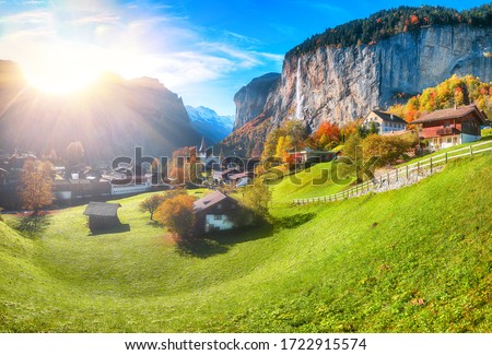 Astonishing autumn view of Lauterbrunnen valley with gorgeous Staubbach waterfall and Swiss Alps in the background.  Location: Lauterbrunnen village, Berner Oberland, Switzerland, Europe.