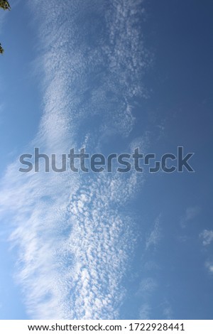 Picture of a clear blue sky, with clouds scattered around, as if they are broken clouds