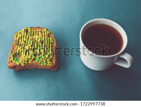 Retro vintage view of avocado sandwich and a cup of filter coffee with side illuminated dramatic looking, copy space