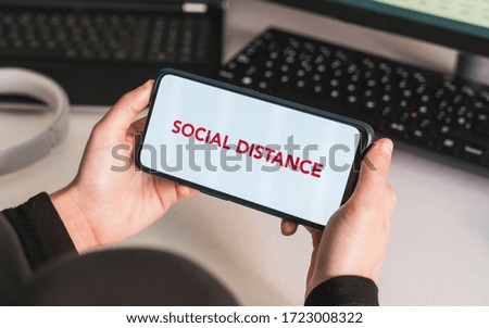 Social distance. Put your message on the phone. Hands of a woman holding a mobile phone with a blank screen to put a text message or advertising content. Coronavirus devices.