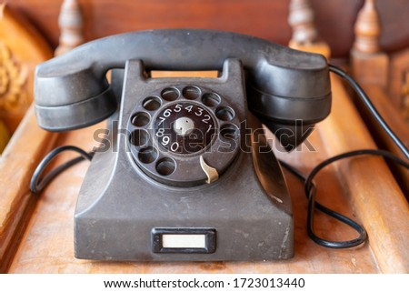 Old telephone with dial disk. A vintage and black telephone made of bakelite.