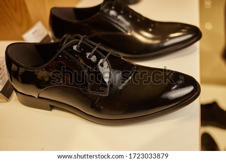 Stylish leather men's shoes on the shelf in the store. Black / brown men's shoes on the stand. Male style, fashion. Gathering the groom. men's shoes. close up shot