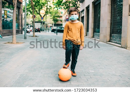 Little boy playing football with a mask