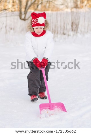Pretty little girl shoveling snow.