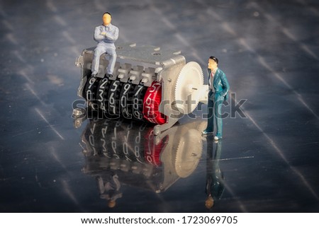 Miniature model of businessmen on an electricity meter counter with motion of the digits. Conceptual image.
