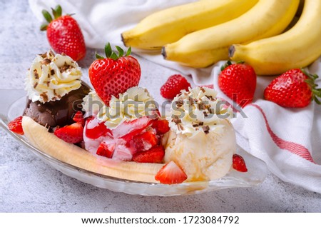 Sweet homemade banana split sundae with chocolate vanilla and strawberry ice cream on glass bowl, decorated topping fresh strawberries.  Royalty-Free Stock Photo #1723084792