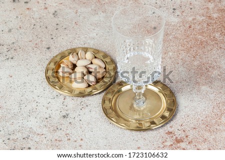 Antique brass coasters, small dish with wineglass on concrete background. Copy space for text and photography props.