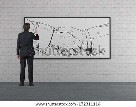 Businessman drawing a handshake in a whiteboard