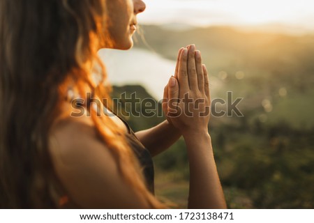 Woman praying alone at sunrise. Nature background. Spiritual and emotional concept. Sensitivity to nature Royalty-Free Stock Photo #1723138471
