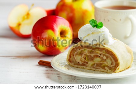 Strudel with Apple and cinnamon. Traditional layered homemade pie with fruit filling, served with powdered sugar and vanilla ice cream. Delicious dessert. Selective focus, copy space