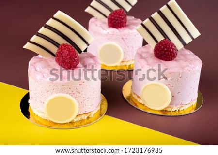 Raspberry vanilla and white chocolate mousse dessert with logo space isolated on yellow and brown. Minimalist conceptual design, flat lay with space for copy text, simple colorful paper background