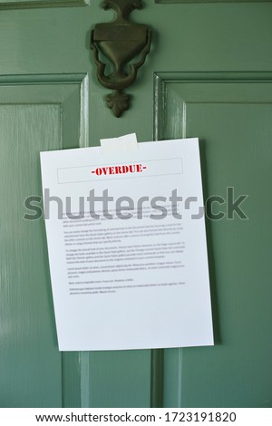 Sign reading Overdue is taped to a front door - Late Bills - Rent - Mortgage - Loan 