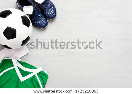 Soccer equipment on grey wooden background. Kids sport concept.