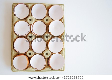 Eggs on cardboard tray stock image. Egg shell in a box. Broken egg shell in egg box 