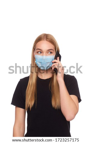 The girl in the medical mask is in home isolation and is talking on the phone with relatives. Studio photography on a white background