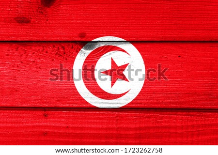 Tunisia flag painted on old wood plank background. Brushed natural light knotted wooden board texture. Wooden texture background flag of Tunisia