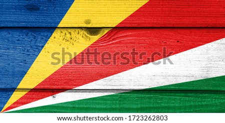 Seychelles flag painted on old wood plank background. Brushed natural light knotted wooden board texture. Wooden texture background flag of Seychelles