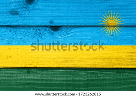 Rwanda flag painted on old wood plank background. Brushed natural light knotted wooden board texture. Wooden texture background flag of Rwanda
