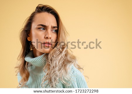 Suspicion. Doubt, mistrust concept. Doubtful woman looking with disbelief expression. Young beautiful emotional woman. Human emotions, facial expression concept. Studio. Isolated on yellow background Royalty-Free Stock Photo #1723272298