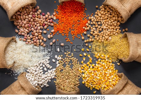Different type of raw dry legumes composition. White beans, lentils, bulgur, chickpeas, kidney beans, corns, rice, in burlap sack Mix organic legume concept Royalty-Free Stock Photo #1723319935