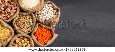 Different type of raw dry legumes composition. White beans, lentils, bulgur, chickpeas, kidney beans, corns, rice, in burlap sack Mix organic legume concept Royalty-Free Stock Photo #1723319938