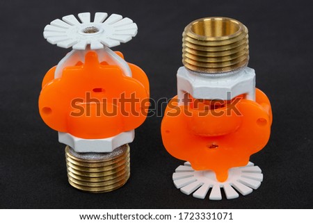 Close up image of fire sprinkler with fire in background. Fire sprinklers are part of an integrated water piping system designed for life and fire safety.