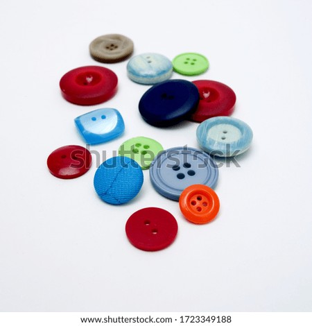 A closeup high angle shot of colorful buttons on a white background