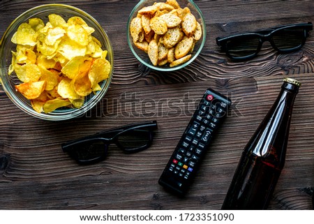 watching movies set with chips on wooden background top view