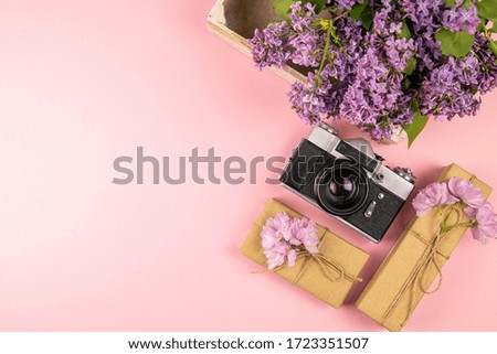 Camera, gift and a beautiful purple lilac. Month - May, June and July. Top views with clear space.