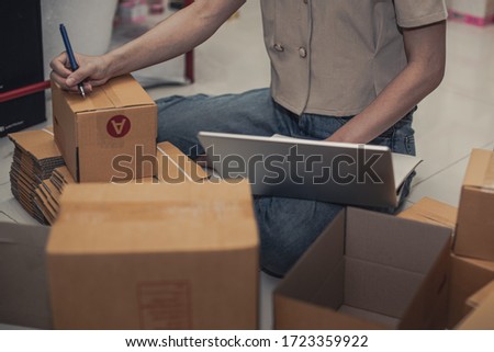 Female business owner working, packing the order for shipping to customer. Female entrepreneur packaging box for delivery. Royalty-Free Stock Photo #1723359922