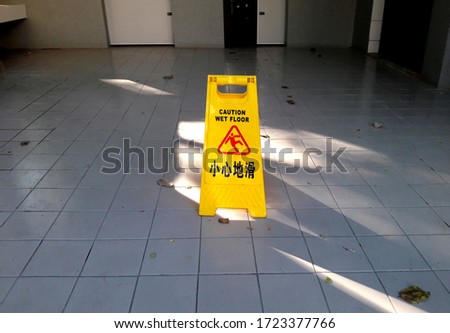 Warning signs for toilet cleaning progress, yellow signs warn the floor is wet (Chinese meaning: Attention, the floor will slip)