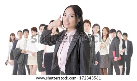 Attractive Asian business woman give you a phone call sign and stand in front of her team.