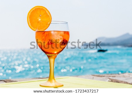 Glass of vermouth in front of the sea Royalty-Free Stock Photo #1723437217