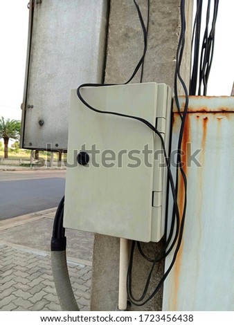 Electrical metal box on posts isolated on brick worm and blue sky background closeup.