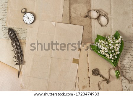 Old paper, feather pen, vintage accessories and spring flowers. Nostalgic background