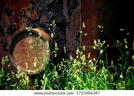 An old rusty metal cistern in the grass.