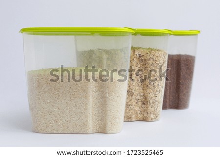 various groats in containers or jars on a white background. Rice, oatmeal and buckwheat