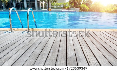 Swimming pool with stair and wooden deck. Royalty-Free Stock Photo #1723539349