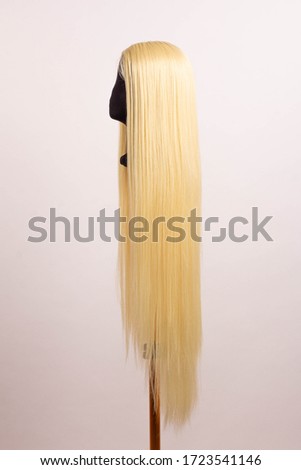 Long hair blonde wig on a mannequin on a white background
