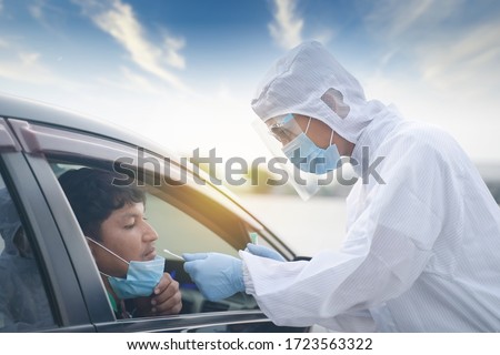 Medical worker in protective suit screening driver to sampling secretion to check for Covid-19. Drive thru test coronavirus fast track. Concept prevention coronavirus outbreak. Royalty-Free Stock Photo #1723563322