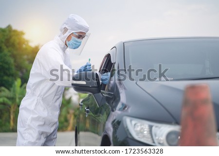 Medical worker in protective suit screening driver to sampling secretion to check for Covid-19. Drive thru test coronavirus fast track. Concept prevention coronavirus outbreak. Royalty-Free Stock Photo #1723563328