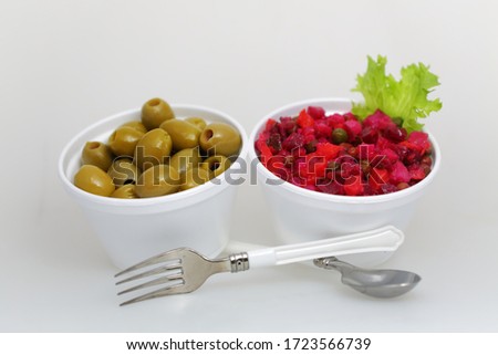 a portion of olives and a portion of vinigret in plastic packaging isolated on white background