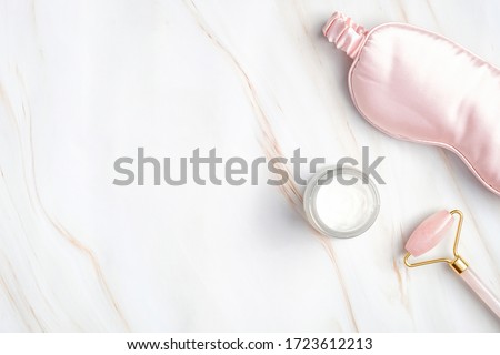 Night care cream for face, sleeping eye mask, facial massage roller on marble background. nighttime skincare routine concept. Royalty-Free Stock Photo #1723612213