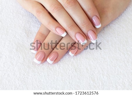 French classic manicure. Female fingers with beautiful nails on white terry towel, close up, selective focus. Spa, skin care, beauty treatment, salon and pretty woman concept Royalty-Free Stock Photo #1723612576