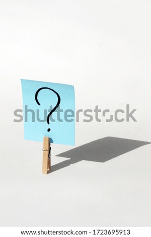 One clothespin with a question mark on the sticker with a big shadow. The concept of business, management, markets, creativity.