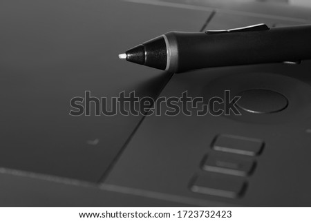 graphic tablet with a pen lying on it background.