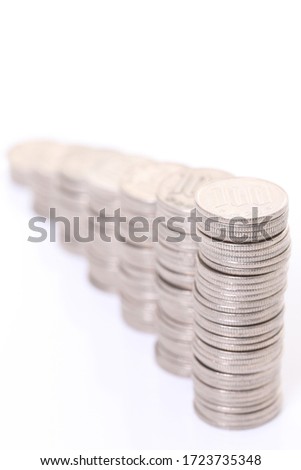 increasing columns of Japanese 100yen coins isolated on white background
