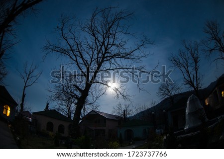Full moon over quiet village at night. Beautiful night landscape of mountain village under the moonlight. Azerbaijan nature. Long exposure shot